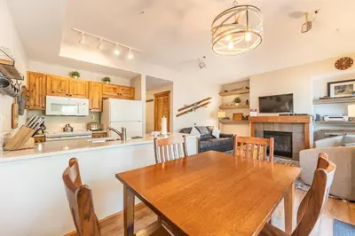 a kitchen and living room with a wooden table and chairs at Seasons at Keystone 1836 in Keystone