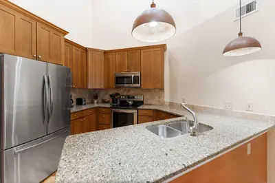 a kitchen with wooden cabinets and a stainless steel refrigerator at Prospect Point Townhomes 202C in Frisco