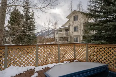 a snow covered fence with a house in the background at Prospect Point Townhomes 202C in Frisco