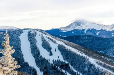 a view of a snow covered mountain range with trees at Saints John 2539 in Keystone