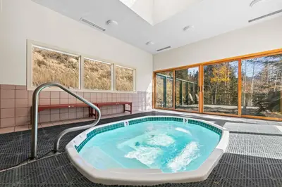 a hot tub in a room with windows at Saints John 2539 in Keystone