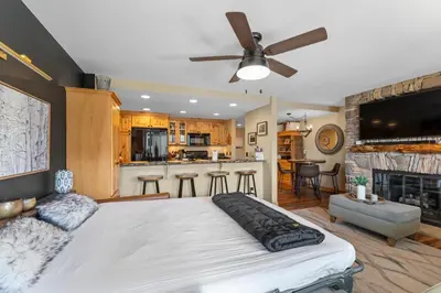 a bedroom with a large bed and a kitchen at Saints John 2539 in Keystone