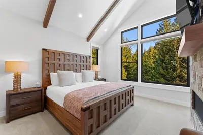 a bedroom with a bed and two large windows at Alcove 75 in Keystone