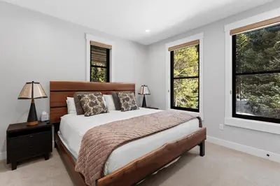 a bedroom with a bed and two windows at Alcove 75 in Keystone