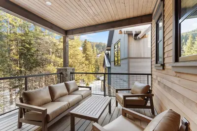 a porch with a couch and chairs on a balcony at Alcove 77 in Keystone