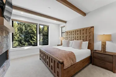 a bedroom with a large bed and a fireplace at Alcove 77 in Keystone