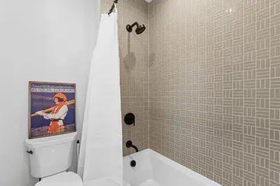 a bathroom with a painting on the wall above a toilet at Alcove 77 in Keystone