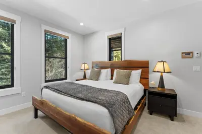 a bedroom with a large bed and two windows at Alcove 77 in Keystone