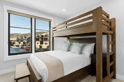 a bedroom with a bunk bed and a large window at Alcove 77 in Keystone