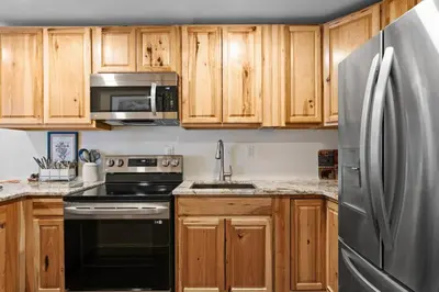 a kitchen with wooden cabinets and a stainless steel refrigerator at Snowdance 103 Building A in Keystone