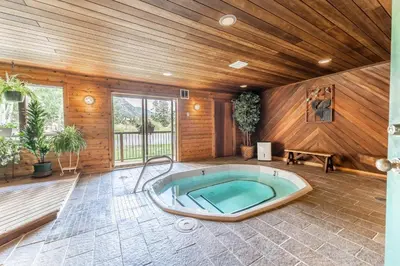 a jacuzzi tub in a room with wooden walls at Snowdance 103 Building A in Keystone