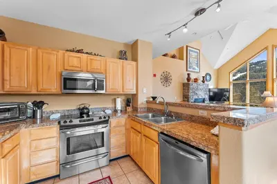 a kitchen with wooden cabinets and stainless steel appliances at Gateway 5036 in Keystone