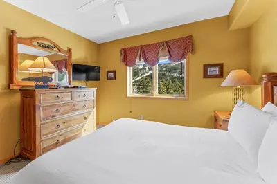 a bedroom with a bed and a dresser and a mirror at Gateway 5036 in Keystone