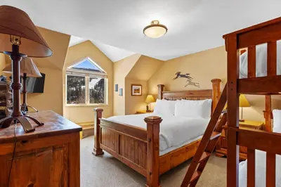 a bedroom with a wooden bed and a desk at Gateway 5036 in Keystone