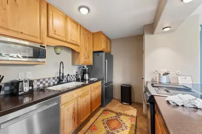 a kitchen with wooden cabinets and a stainless steel refrigerator at Lake Cliffe 307 Building A in Dillon