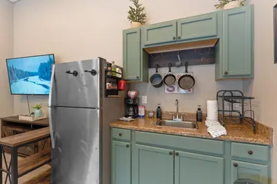 a kitchen with green cabinets and a stainless steel refrigerator at Lakeshore 4 in Keystone