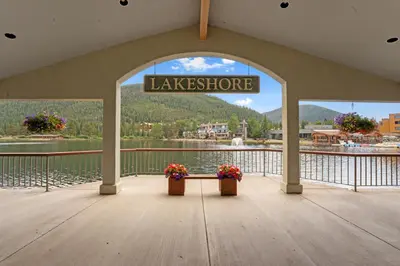 a view of a lake from a dock with two flowers at Lakeshore 4 in Keystone