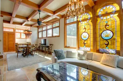 a living room with a couch and stained glass windows at Victorian-Style Cheesman Park Apt - 2 Mi to Dtwn in Denver