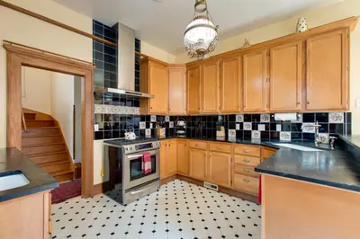 a kitchen with wooden cabinets and a stove top oven at Victorian-Style Cheesman Park Apt - 2 Mi to Dtwn in Denver