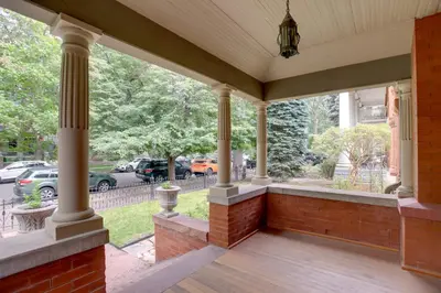 a porch with columns and a view of a street at Victorian-Style Cheesman Park Apt - 2 Mi to Dtwn in Denver