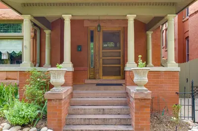 a front door of a house with two vases at Victorian-Style Cheesman Park Apt - 2 Mi to Dtwn in Denver