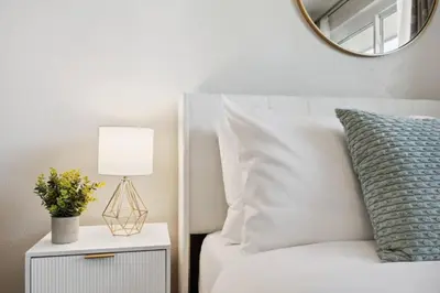 a bedroom with a white bed with a lamp and a mirror at Family-friendly | Ping-Pong | Game Rm | Fast Wifi in Arvada
