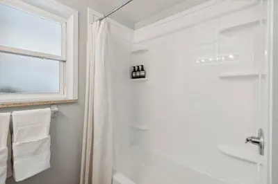 a white bathroom with a shower and a window at Family-friendly | Ping-Pong | Game Rm | Fast Wifi in Arvada