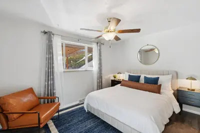 a bedroom with a bed and a chair and a ceiling fan at Family-friendly | Ping-Pong | Game Rm | Fast Wifi in Arvada
