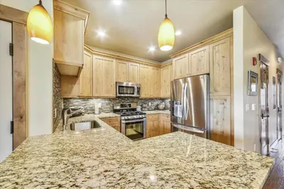 a kitchen with wooden cabinets and a granite counter top at Apartments Off Main #4 in Frisco