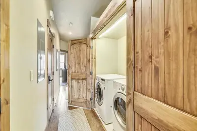 a laundry room with a washing machine and wooden walls at Apartments Off Main #4 in Frisco