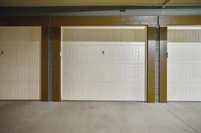 three garage doors in a room with concrete floors at Apartments Off Main #4 in Frisco