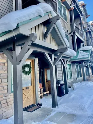 a front door of a house with snow on it at 2 BR Basecamp Bliss at Kicking Horse Near Ski Hill in Granby