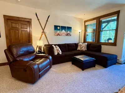 a living room with a leather couch and a chair at 2 BR Basecamp Bliss at Kicking Horse Near Ski Hill in Granby