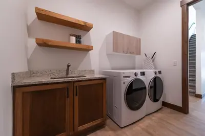 a kitchen with a washing machine and a sink at Zephyr Escape in Fraser