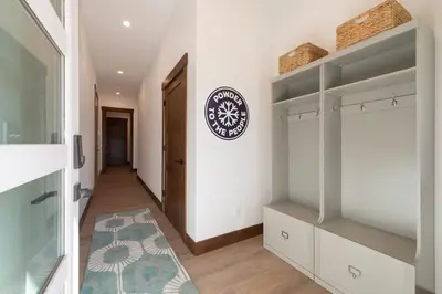 a hallway with white cabinets and a clock on the wall at Zephyr Escape in Fraser