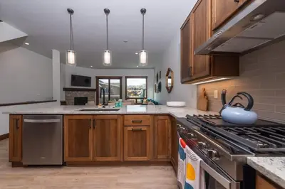 a kitchen with wooden cabinets and stainless steel appliances at Zephyr Escape in Fraser