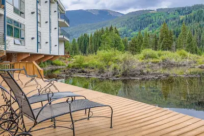 a wooden deck with two chairs on top of a house at 2903 Riverbank Lodge condo in Keystone