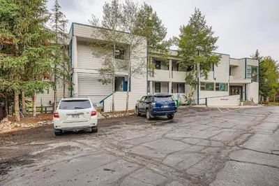 two cars parked in a parking lot in front of a building at 2903 Riverbank Lodge condo in Keystone
