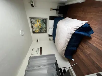 a small bedroom with a bed and a chair at Railway Cabin at Base Camp in Dumont