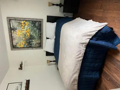 a bedroom with a bed with a blue comforter at Railway Cabin at Base Camp in Dumont