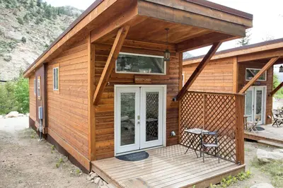 a wooden cabin with a porch and a patio at Miners Cabin at Base Camp Lodging Company in Dumont