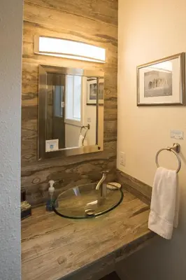 a bathroom with a sink with a large mirror at Miners Cabin at Base Camp Lodging Company in Dumont