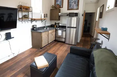 a living room with a couch and a kitchen at Miners Cabin at Base Camp Lodging Company in Dumont