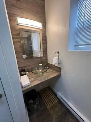 a bathroom with a sink and a mirror at Miners Cabin at Base Camp Lodging Company in Dumont