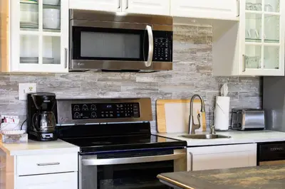 a kitchen with a microwave and a stove top oven at Rocky Mountain Retreat in Granby