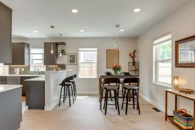 a kitchen with a bar with stools in it at Walk to Med Ctrs and Dtwn Englewood Modern Home in Englewood