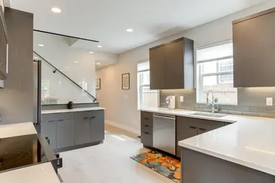 a large kitchen with white counters and gray cabinets at Walk to Med Ctrs and Dtwn Englewood Modern Home in Englewood