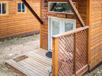 a front door of a wooden cabin with a porch at Iron Horse Cabin at Base Camp Lodging Company in Dumont