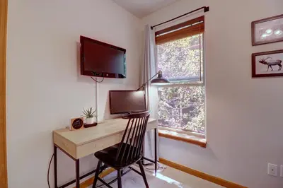 a room with a desk with a television and a window at 122 Lookout Ridge townhouse in Dillon