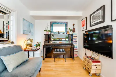 a living room with a piano and a television at Trail Access, Hot Tub Lakefront Boulder Retreat! in Boulder